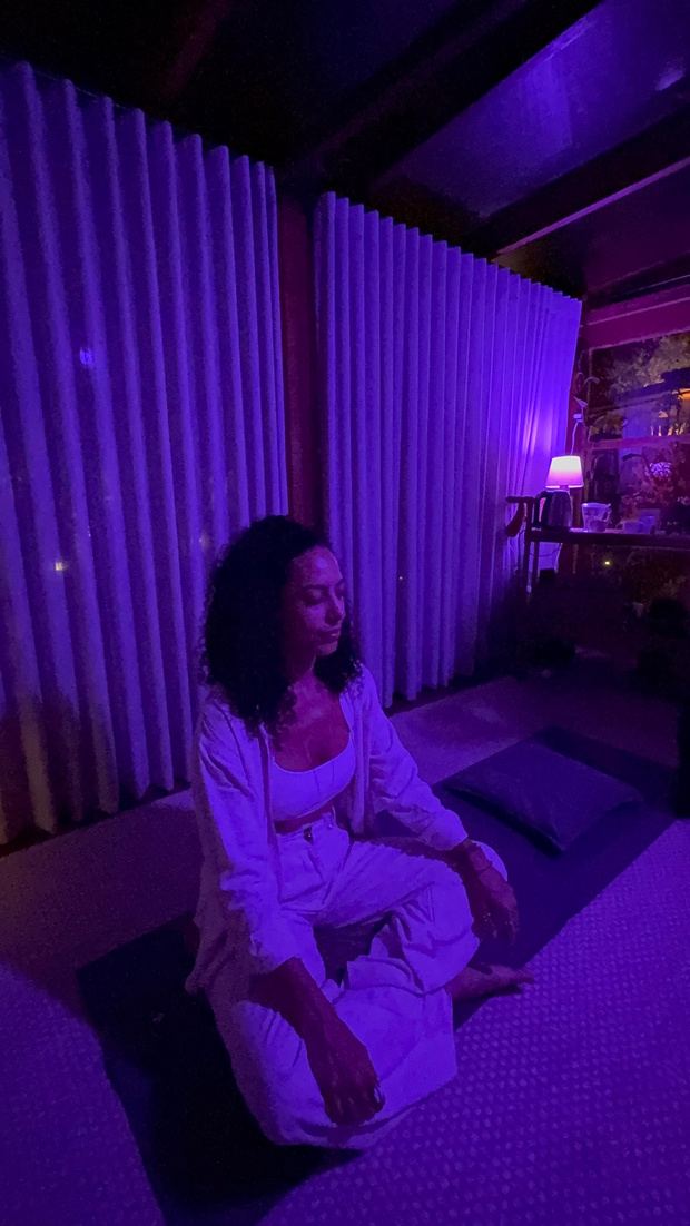 Mulher meditando sentada sobre almofadas na tenda